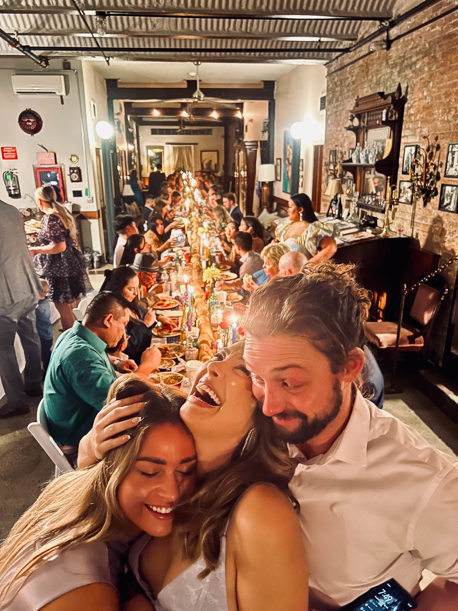 A group of people sitting at a long table with candles and food